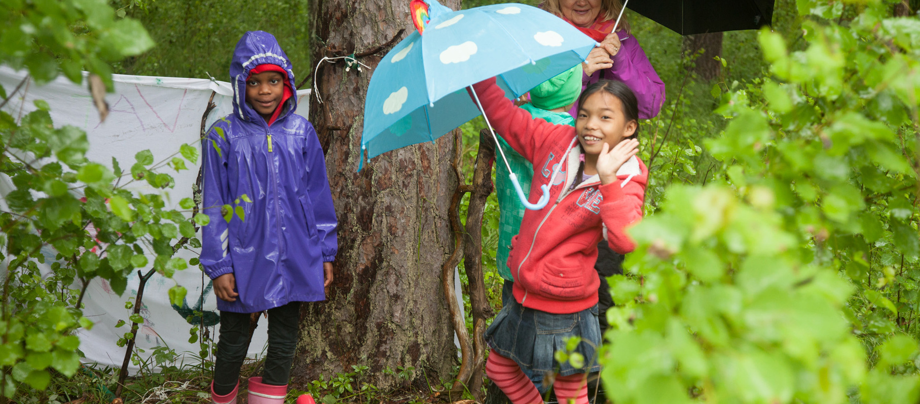 lapset sateessa sateenvarjojen alla kesäleirillä