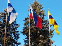 Toksovan ystävyysseurakunnan pihalle 3 lippua. Vasemmalta oikealle Suomen, Venäjän ja Inkerinmaan lippu