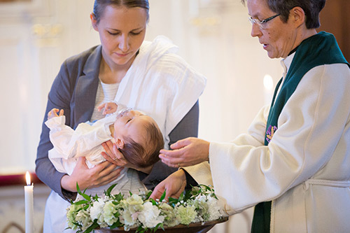 Pappi kastamassa pientä lasta