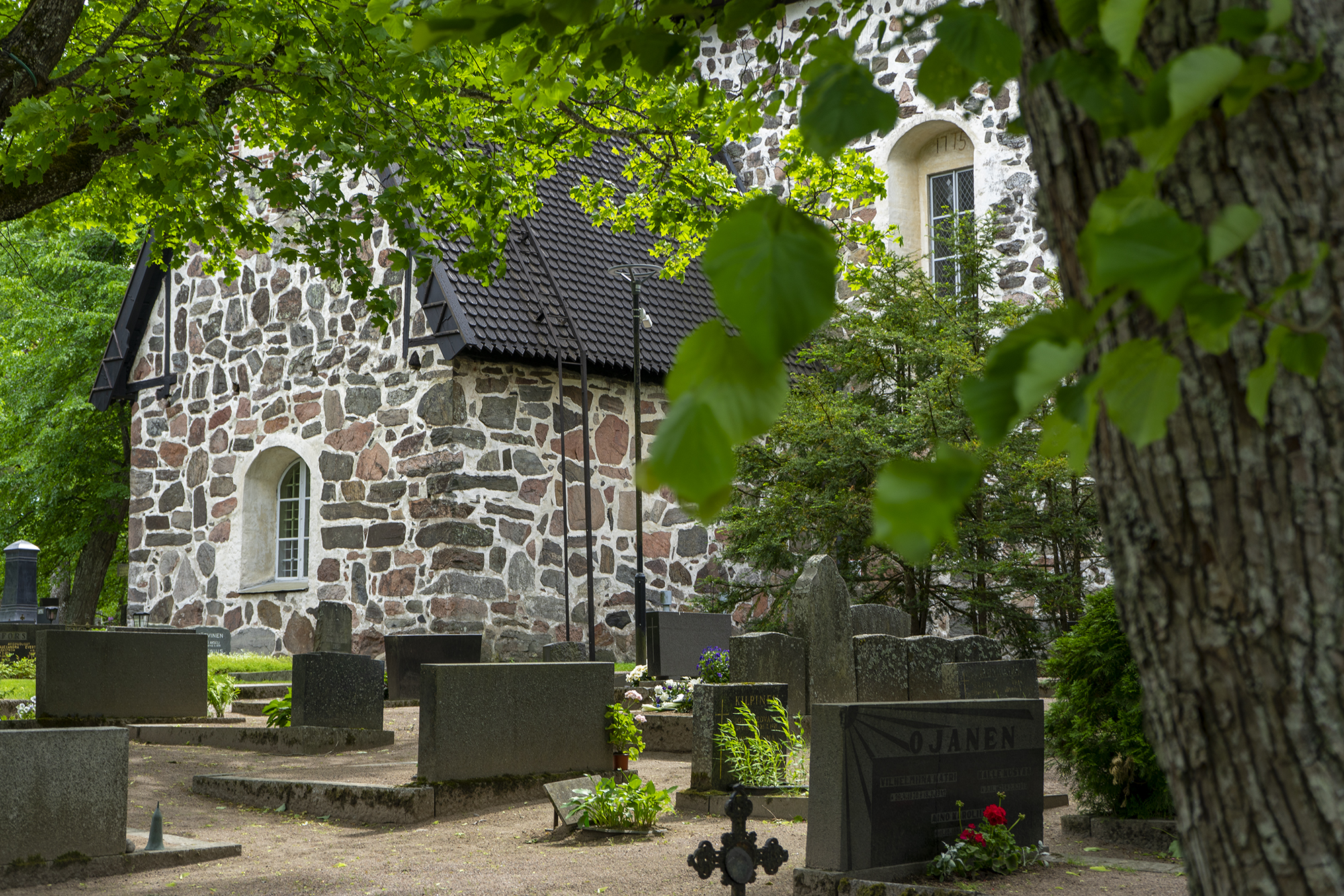 Pyhän Laurin kirkko kuvattu ulkopuolelta kesän vihreydessä.