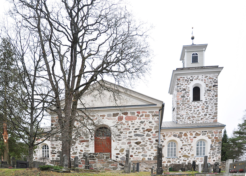 Nummen kirkon ulkokuva eteläpäädystä, lehdetön puu vasemmalla edustalla, ympärillä hautausmaa
