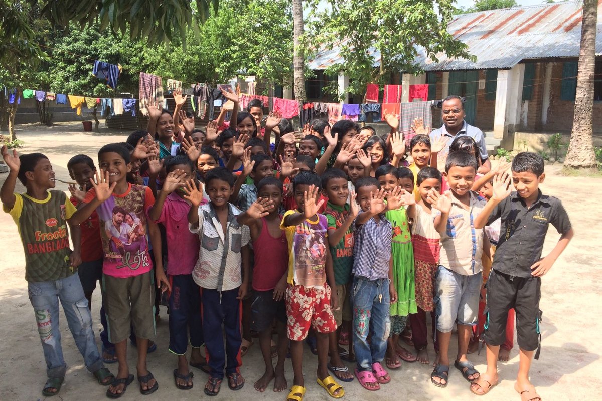 Kuvassa joukko bangladeshilaisia lapsia vilkuttaa kameralle.