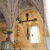 Valokuva Pyhän Laurin kirkon sisältä. Kuvassa näkyy saarnastuoli sekä krusifiksi.