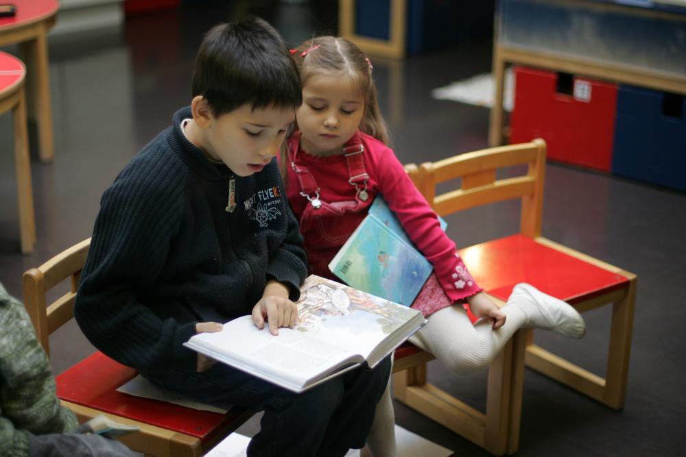 Tyttö ja poika lukevat kuvitettua raamatunkertomusta.